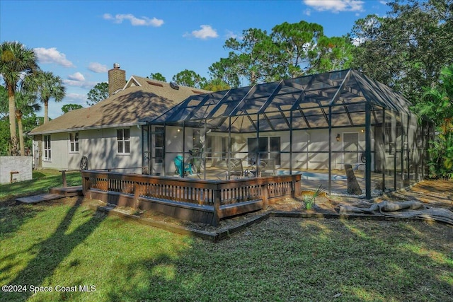 back of property featuring a lawn and glass enclosure