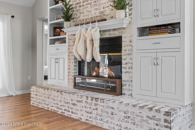 interior space featuring wood-type flooring and a brick fireplace