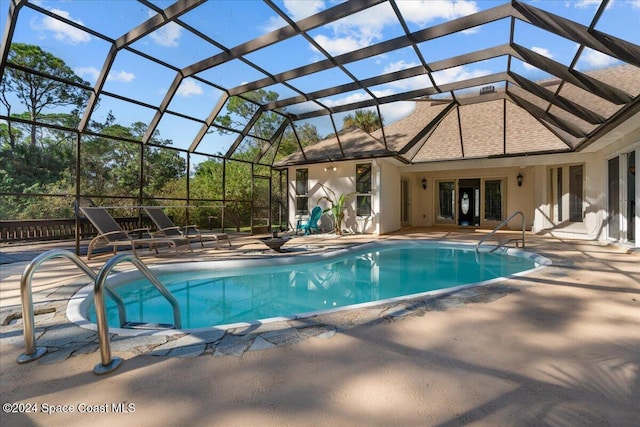 view of swimming pool featuring a patio and glass enclosure