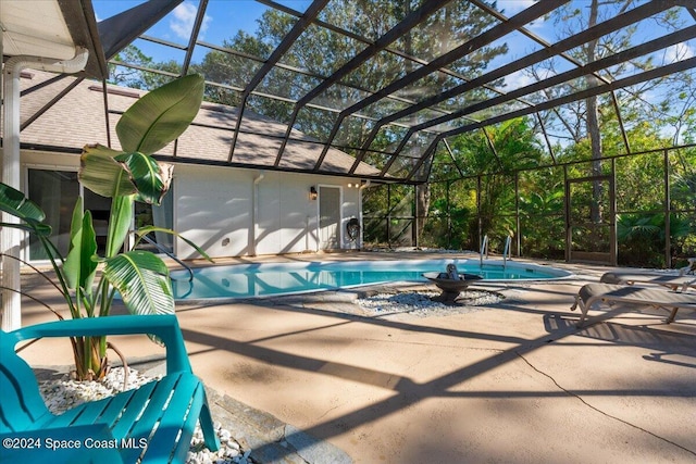 view of pool with glass enclosure and a patio area