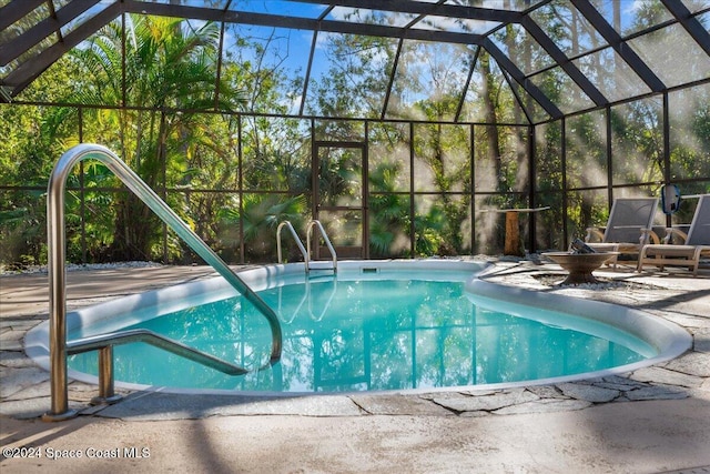 view of pool with glass enclosure and a patio area