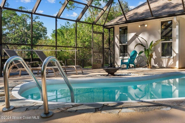 view of pool featuring glass enclosure and a patio area