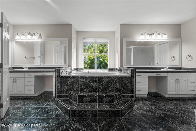 bathroom featuring vanity and tiled tub