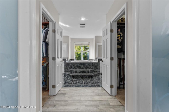 bathroom featuring hardwood / wood-style flooring and tiled tub