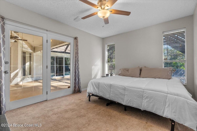 carpeted bedroom featuring a textured ceiling, access to outside, multiple windows, and ceiling fan