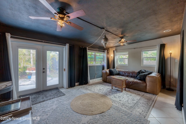 living room featuring ceiling fan, french doors, light tile patterned flooring, and plenty of natural light