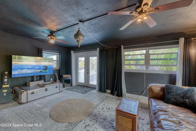 living room with french doors, a textured ceiling, a wealth of natural light, and ceiling fan