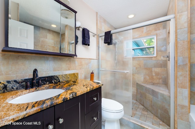 bathroom with walk in shower, a textured ceiling, vanity, tile walls, and toilet