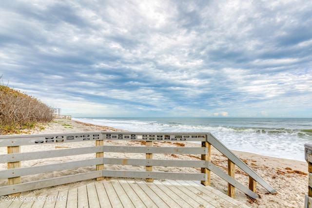 surrounding community featuring a beach view and a water view