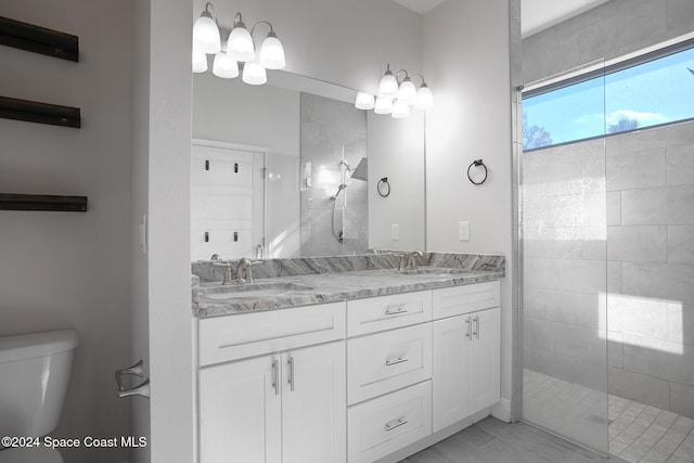 bathroom featuring vanity, toilet, and tiled shower