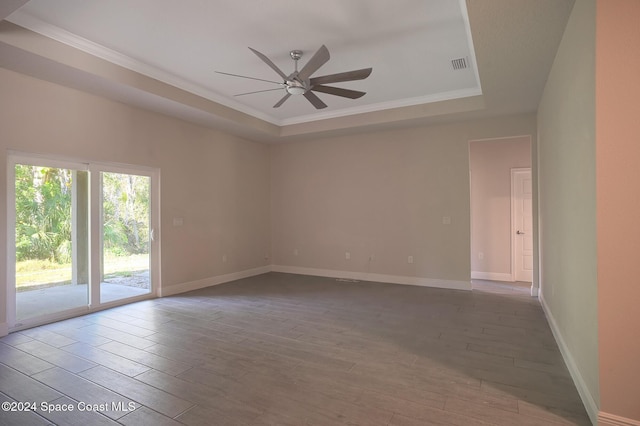 spare room with ceiling fan, a raised ceiling, ornamental molding, and light hardwood / wood-style flooring