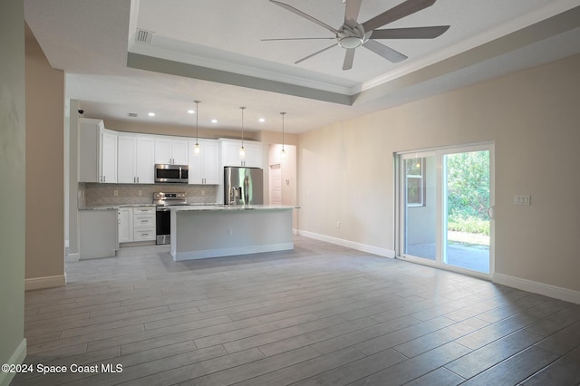 kitchen with stainless steel appliances, crown molding, light hardwood / wood-style floors, decorative light fixtures, and white cabinets