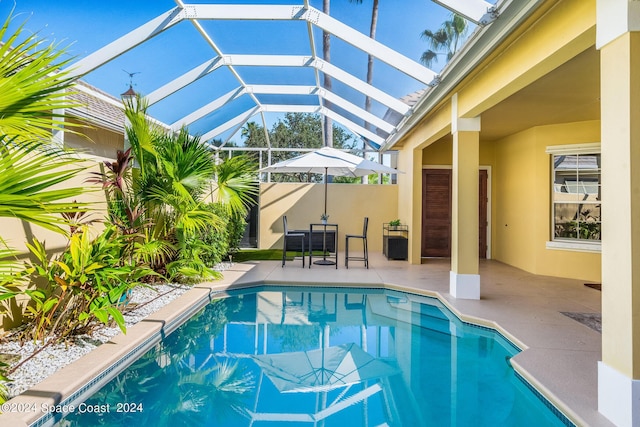 view of swimming pool with a patio and a lanai