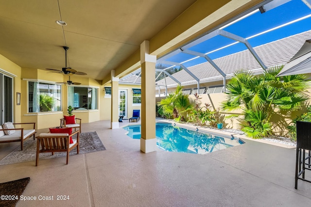 view of swimming pool with a lanai, ceiling fan, and a patio