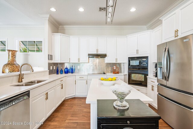 kitchen with tasteful backsplash, sink, black appliances, white cabinets, and a center island