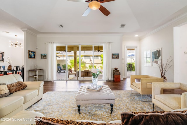 living room featuring ceiling fan with notable chandelier, dark hardwood / wood-style floors, and ornamental molding