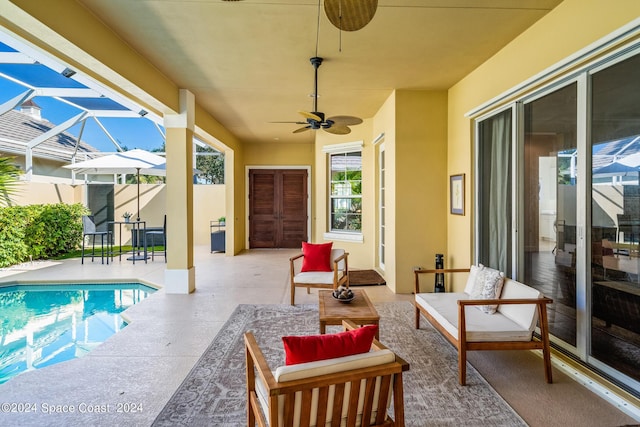 view of pool with a lanai, outdoor lounge area, ceiling fan, and a patio