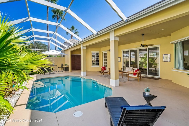 view of swimming pool with a patio area, ceiling fan, outdoor lounge area, and glass enclosure