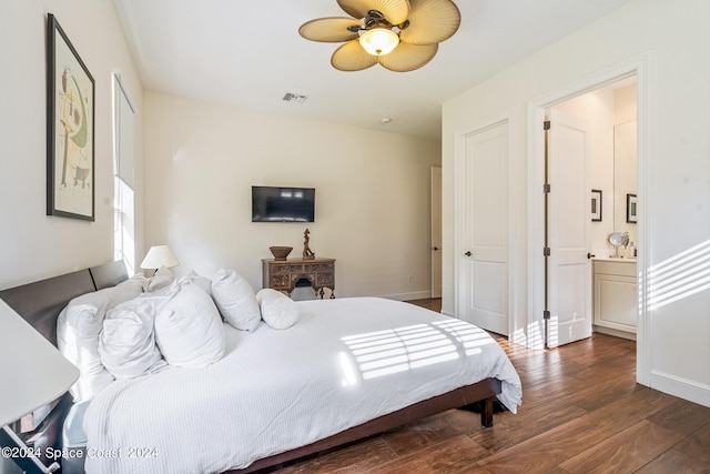 bedroom featuring ensuite bath, ceiling fan, and dark wood-type flooring