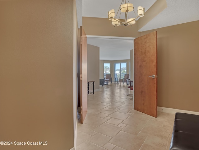 hallway with an inviting chandelier