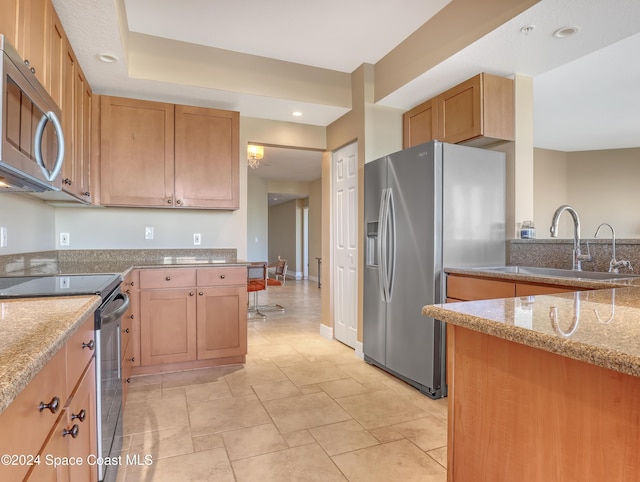 kitchen featuring light stone countertops, sink, and appliances with stainless steel finishes