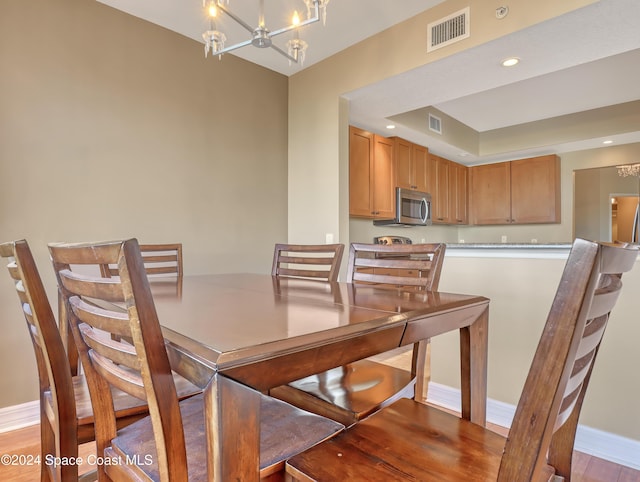 dining area featuring a notable chandelier and light wood-type flooring