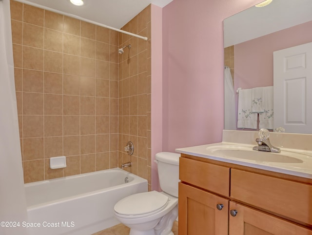 full bathroom featuring tiled shower / bath, vanity, and toilet