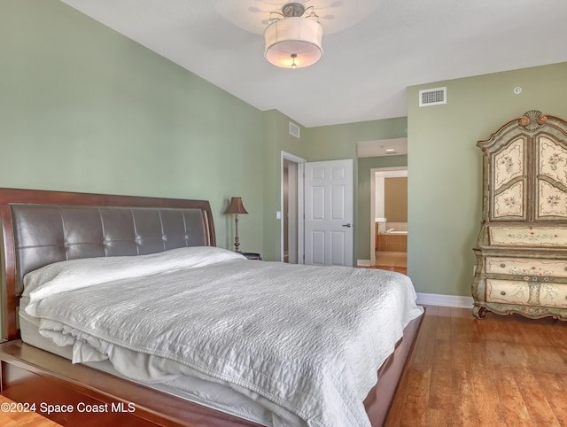 bedroom with wood-type flooring and ensuite bath