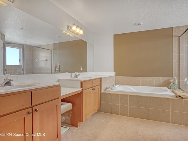 bathroom featuring tile patterned flooring, vanity, a textured ceiling, and plus walk in shower