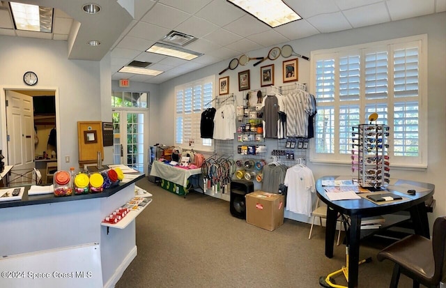 recreation room featuring a paneled ceiling, carpet floors, and a wealth of natural light