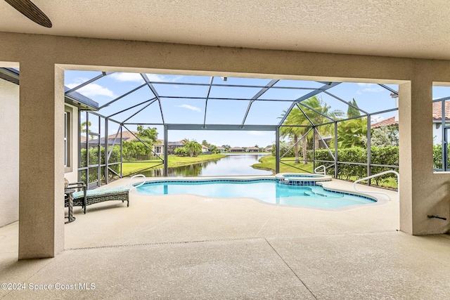 view of pool with an in ground hot tub, a water view, a patio area, and a lanai