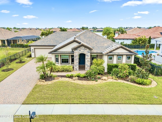 view of front of property with a garage, a fenced in pool, and a front yard