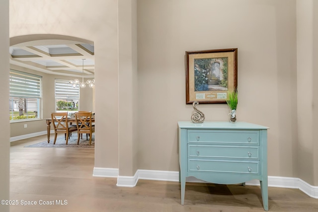 hall with coffered ceiling, beamed ceiling, and light wood-type flooring