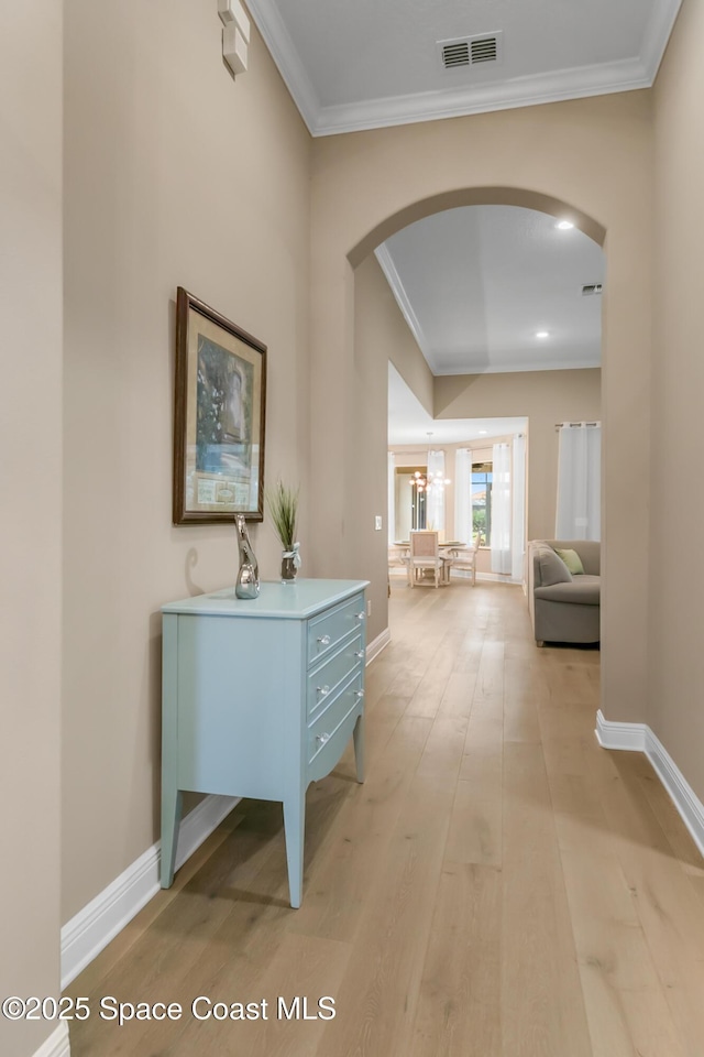 corridor featuring ornamental molding and light hardwood / wood-style floors