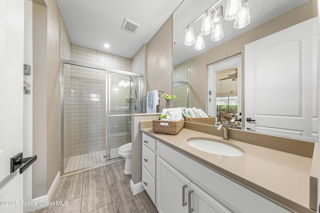 bathroom with vanity, an enclosed shower, and toilet