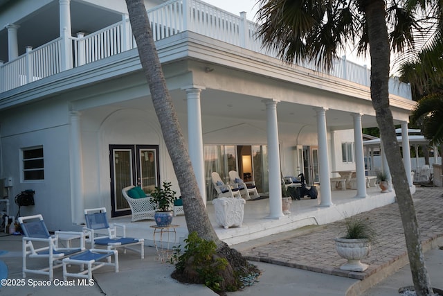 back of property featuring a patio and a balcony