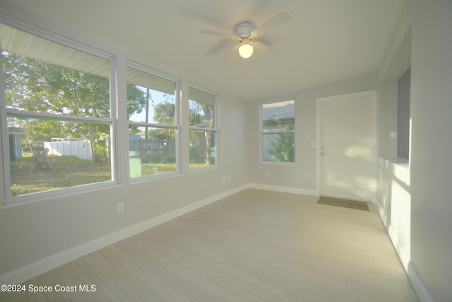 empty room featuring ceiling fan and a healthy amount of sunlight