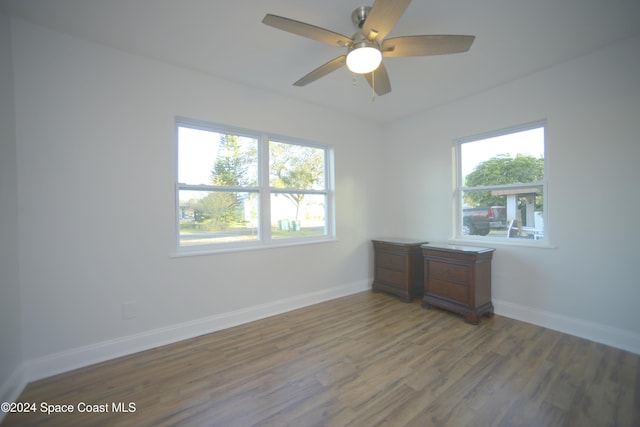 spare room featuring hardwood / wood-style floors, ceiling fan, and a healthy amount of sunlight