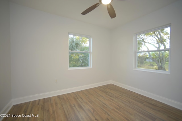 spare room featuring a wealth of natural light, dark hardwood / wood-style flooring, and ceiling fan