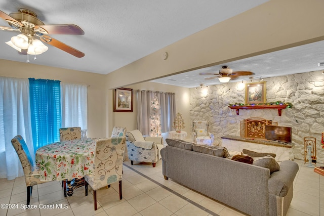 dining area featuring ceiling fan, light tile patterned flooring, and a textured ceiling