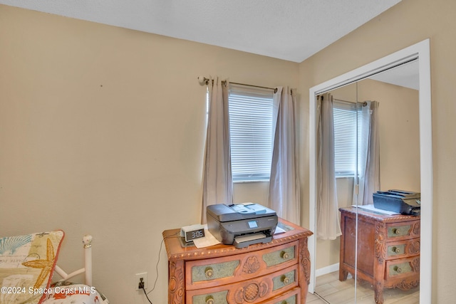 bedroom featuring a closet, light tile patterned flooring, and multiple windows