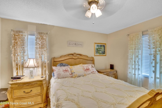 bedroom with a textured ceiling and ceiling fan