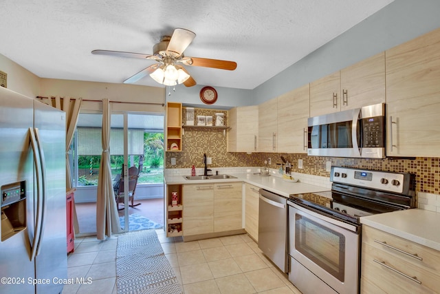 kitchen with light brown cabinets, sink, appliances with stainless steel finishes, and tasteful backsplash