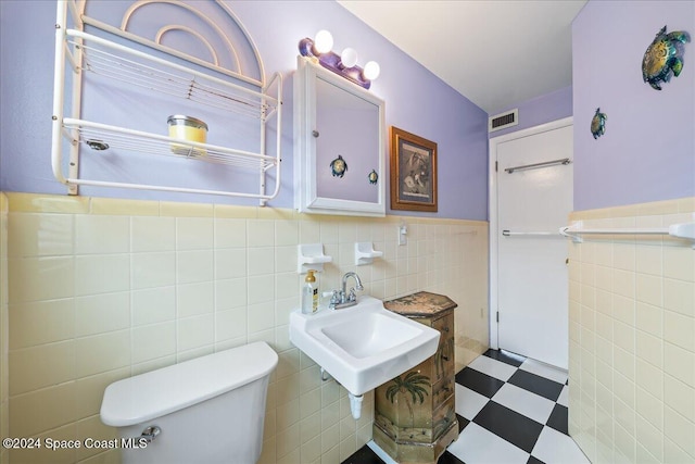 bathroom with tile walls and toilet