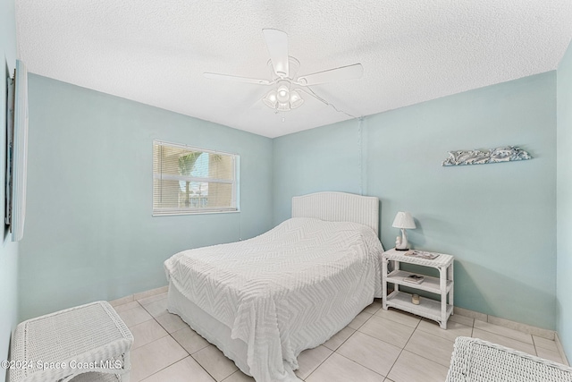 tiled bedroom with a textured ceiling and ceiling fan