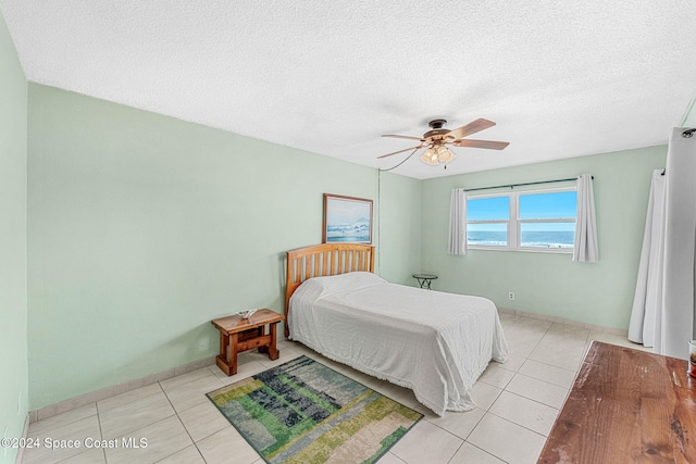 bedroom with light tile patterned floors, a textured ceiling, and ceiling fan