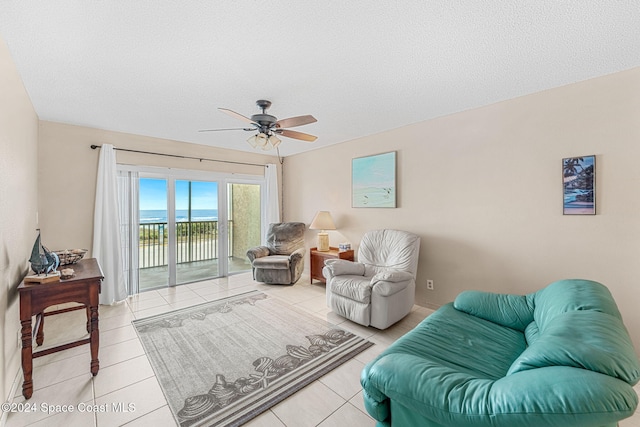 living room featuring tile patterned flooring, a textured ceiling, and ceiling fan