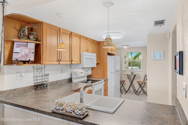 kitchen with kitchen peninsula, white appliances, sink, light tile patterned floors, and decorative light fixtures