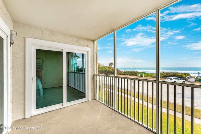 unfurnished sunroom featuring a water view