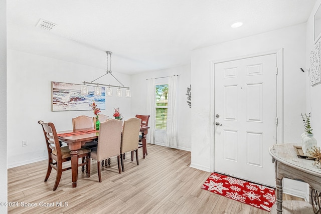 dining area featuring a notable chandelier and light wood-type flooring